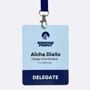 Badge Délégué avec Lanyard – IDCGO Badge délégué avec lanyard affichant le nom Aïcha Diallo, coordinatrice cargo chez Bridge Point, au design bleu et blanc.